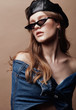 © monchak - Fashion portrait of beautiful young woman in leather beret cap, denim jacket and cat eye retro sunglasses