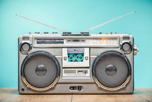 Retro Outdated Portable Stereo Boombox Radio Receiver With Cassette Recorder From Circa Late 70s Front Aquamarine Wall Background. Listening Music Concept. Vintage Old Style Filtered Photo
