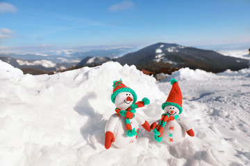 Sticker - Two toy snowmen at mountain resort on sunny frosty day. Winter vacation