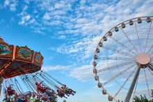 Ferris Wheel And Carousel In Motion Blur At Oktoberfest In Munich