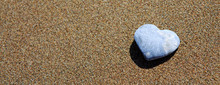 Gray Stone In The Form Of Heart Lies On Sand.
