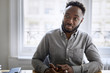 © Cavan Images - Thoughtful businessman sitting at desk in office
