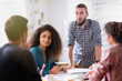 © jackfrog - At office. A young man leads a multiethnic working group