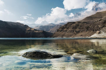 Landscape mountain lake. Natural high reservoir with epic rocks in the background. North Caucasus. Russia. Bylhum village