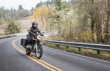 Female Biker Riding Motorcycle On Country Road