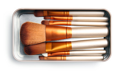 Box with makeup brushes of professional artist on white background