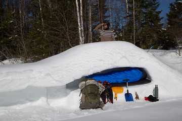 Snow cave, cross section, man standing outside, looks into the distance