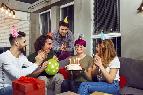 Zdjęcie XXL Przyjaciele z ciasta z świece obchodzi urodziny na imprezie w pokoju.