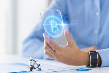 Sticker - business, technology and cryptocurrency concept - close up of woman hand holding and showing transparent smartphone with bitcoin on screen