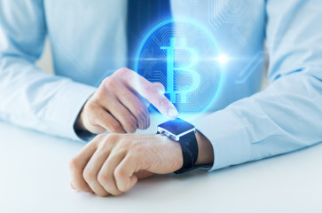 Canvas Print - business, technology and cryptocurrency concept - close up of male hand wearing smart watch with bitcoin on screen