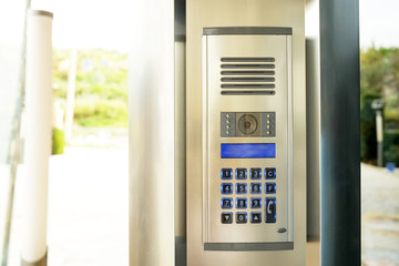 Close up of security system code device with numbered buttons on modern intercom device with blue lcd screen near entrence door. Electronic coded lock. Copy space.