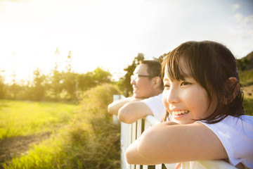 Wall Mural - Father with daughter enjoy the view at sunset