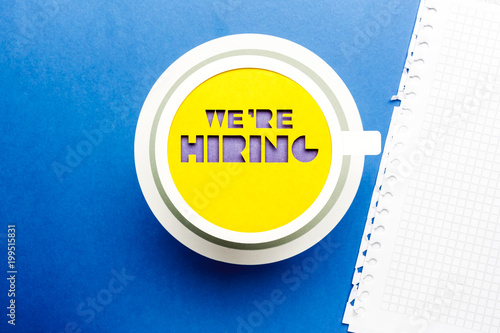 Fotografía We are hiring concept. Yellow paper cup on blue background.