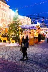 Portrait in full growth, Russian beautiful woman in a mink coat on the Red Square in Moscow in Christmas time