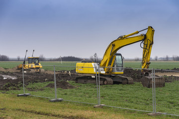 Excavators and bulldozers preparing the ground for the construction of a factory