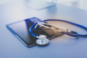 Wall Mural - Medical equipment: blue stethoscope and tablet on white background. Medical equipment