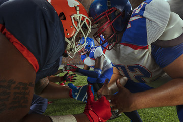 Wall Mural - American football players preforms an action play in professional sport stadium