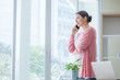 © iammotos - businesswoman talking on smartphone and standing in modern office