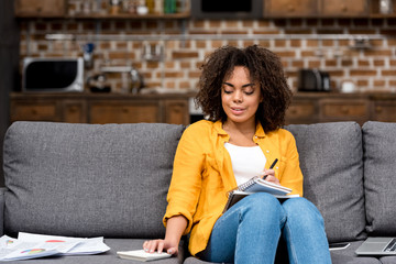 Wall Mural - attractive young woman working at home on couch