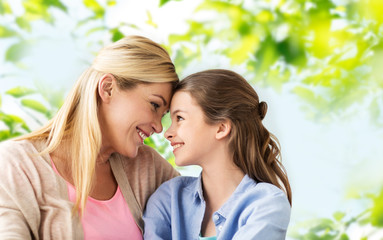 Wall Mural - people and family concept - happy smiling mother and daughter over green natural background