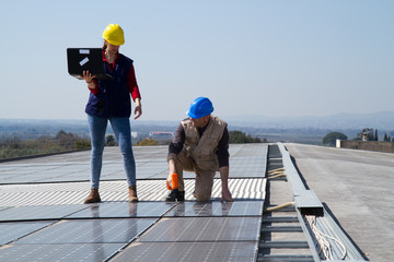 Wall Mural - young engineer girl and an elderly skilled worker fitting a photovoltaic plant