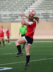 soccer player heading the ball during a match