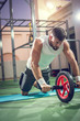 © Bojan - Handsome sportsman workout with abdominal roller