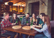 © davit85 - Friends having a drinks in a bar, They are sitting at a wooden table with beers and pizza.