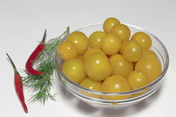 Wall Mural - Raw yellow cherry tomatoes in the glass dish closeup, ready to eat, isolated on white, vegan food.