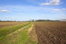 Farm Ditch With Plowed Fields