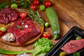 Wall Mural - Still life of raw beef meat with vegetables on wooden plate over white background, top view, selective focus