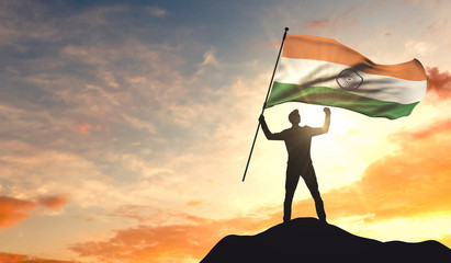 Canvas Print - India flag being waved by a man celebrating success at the top of a mountain. 3D Rendering