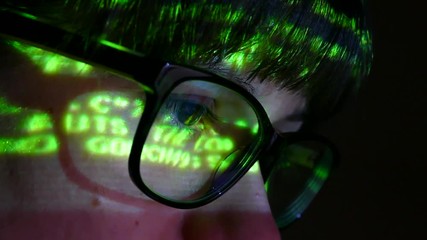 the programmer works at the computer over the program in a dark room. the hacker performs banned fin