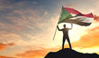 Sudan flag being waved by a man celebrating success at the top of a mountain. 3D Rendering