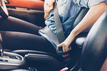 asian woman fastening seat belt in the car, safety concept