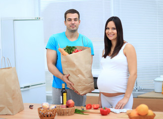 Wall Mural - Husband and pregnant wife are considering the products in the package