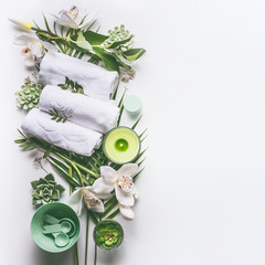 Wall Mural - green spa or wellness background with towels, candle, tropical leaves , orchid flowers, succulents a