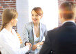 © ASDF - handshake of a Manager, and a client sitting behind a Desk
