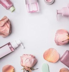 Wall Mural - roses cosmetics frame with toner,serum, essence,moisturizer and others on white desktop background, 