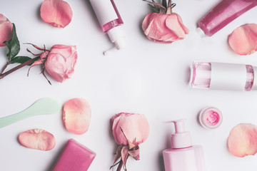 Wall Mural - flat lay frame of flowers and cosmetics products with rose essential oil: toner,serum, essence,moist