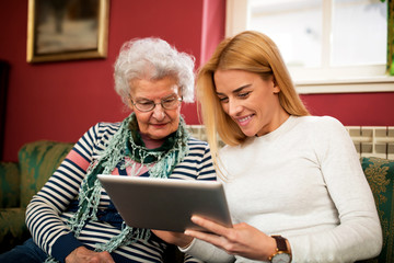 Wall Mural - Two generation using tablet and smiling together