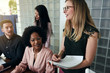 © Flamingo Images - Smiling businesswoman talking with diverse coworkers in an office