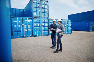 Two engineers standing in a freight yard shaking hands together