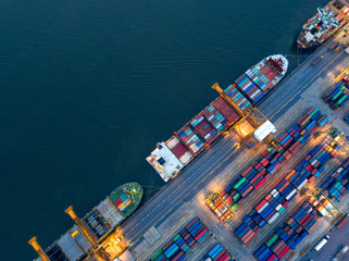 Aerial view of business port with shore crane loading container in container ship in import/export and business logistics with crane and shipping cargo.International transportation concept.