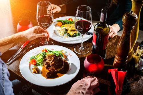 Fotografía Couple having romantic dinner in a restaurant in rays of the sun