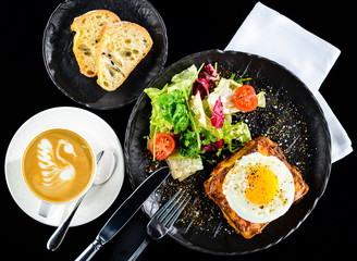 Wall Mural - Dish with toast with fried eggs and salad with tomatoes and lettuce leaves at the cafe