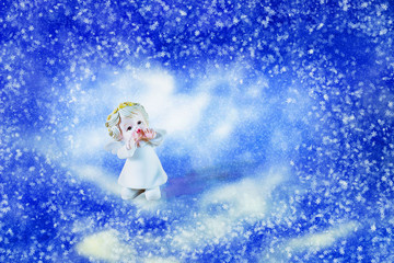  Little angel on winter background of blue sky with snow. For Christmas, New Year and love in Valentine's Day. With copy space.