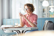 © pressmaster - Young woman with smartphone reading notification or texting in messenger while spending time in cafe