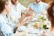 © pressmaster - Young man pouring homemade lemonade in glass of his girlfriend while having dinner with friends
