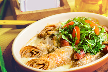 Canvas Print - Delicious pancake blini with sausages, tomatoes and basil leaves in rays of the sun. New restaurant menu for the holiday Maslenitsa